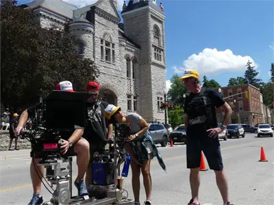 Film crew on outdoor set with equipment