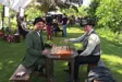 Two actors playing chess at a table 