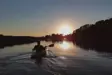 Man kayaking at sunset