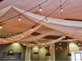 White draping with string lights from ceiling 