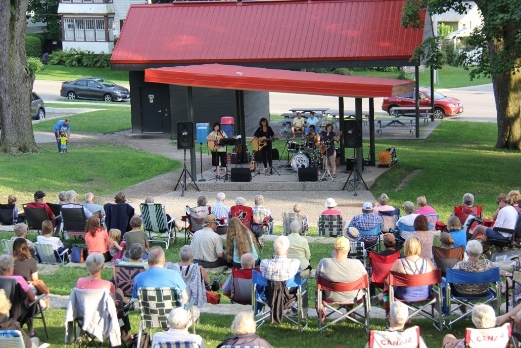 Photo of musicians performing for crowd at outdoor park